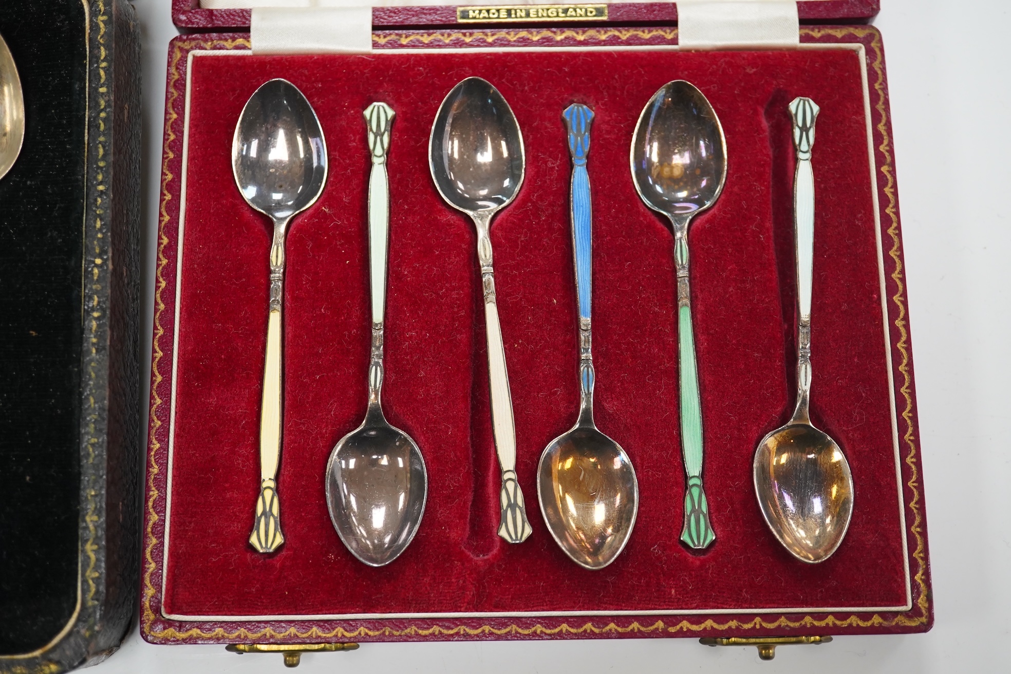 A set of six silver grapefruit spoons, Cooper Brothers & Sons, Sheffield, 1936, a modern pair of silver mounted dwarf candlesticks, a silver egg cup and spoon and a set of six silver gilt and enamelled coffee spoons, all